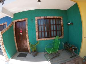 a room with two doors and a green wall at Vila da Drika in Rio das Ostras