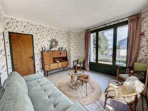 een woonkamer met een bank en een tafel bij Maison Jullouville, 7 pièces, 10 personnes - FR-1-361-375 in Jullouville-les-Pins