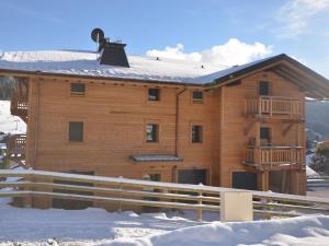 a large wooden house in the snow with a fence at Appartement Les Gets, 3 pièces, 6 personnes - FR-1-623-98 in Les Gets