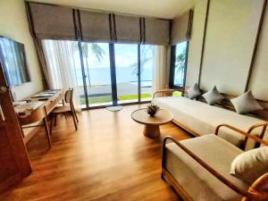 a living room with a couch and a table at Supalai Scenic Bay Resort And Spa, SHA Extra Plus in Por Bay