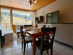 a dining room with a table with chairs and a television at Appartement Chamrousse, 2 pièces, 4 personnes - FR-1-549-69 in Chamrousse