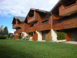 un gran edificio con un césped verde delante de él en Appartement Samoëns, 2 pièces, 5 personnes - FR-1-629-38, en Samoëns