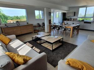 a living room with a couch and a table at Gîte familial avec piscine privative chauffée, terrasse sur le Loir et proche du Zoo de La Flèche - FR-1-410-329 in La Flèche