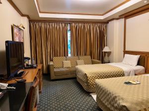 a hotel room with two beds and a television at Taksilahotel in Maha Sarakham