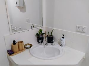 a white sink in a bathroom with a mirror at 2BR luxury house in Piccadilly in Kalgoorlie +19 photos