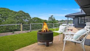 a fire pit on a patio with two chairs and a table at Hoddle Lane in Robertson +17 photos