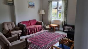 a living room with a couch and chairs and a rug at The Tussocks, Arthur's Pass in Arthur's Pass