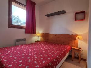 una camera con letto rosso e finestra di Appartement Le Dévoluy, 4 pièces, 8 personnes - FR-1-525-179 a Le Dévoluy