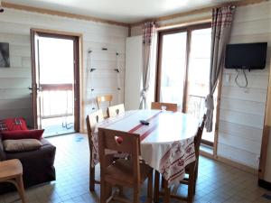 a dining room with a table and chairs and windows at Appartement Albiez-Montrond, 2 pièces, 5 personnes - FR-1-618-5 in Albiez-Montrond
