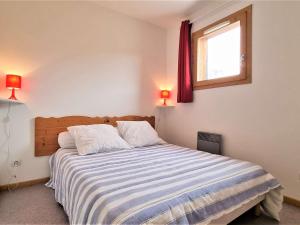 a bedroom with a bed with two pillows and a window at Appartement Le Dévoluy, 2 pièces, 8 personnes - FR-1-525-199 in Le Dévoluy