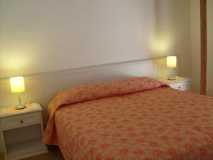 モーディカにあるCasa Vacanze Pucciaのベッドルーム1室(ベッド1台、テーブルにランプ2つ付)