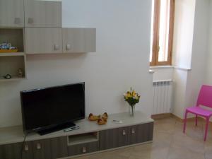 uma sala de estar com uma televisão de ecrã plano sobre uma mesa em Casa Vacanze Puccia em Modica