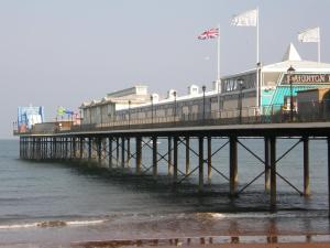a pier with flags on top of the water at Kingswinford Guest House in Paignton