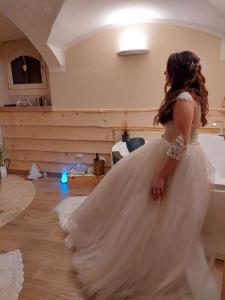Una donna con un abito da sposa in piedi in una stanza di Il nido del pettirosso a Enego