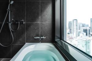 a bath tub in a bathroom with a window at The Royal Park Hotel Iconic Osaka Midosuji in Osaka