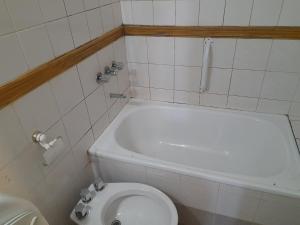La salle de bains est pourvue de toilettes blanches et d'un lavabo. dans l'établissement AzulTDF, à Ushuaia