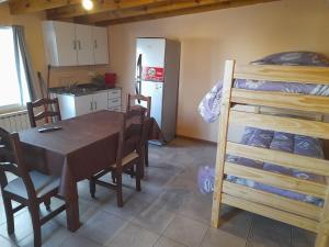 a kitchen and dining room with a table and a bunk bed at AzulTDF in Ushuaia