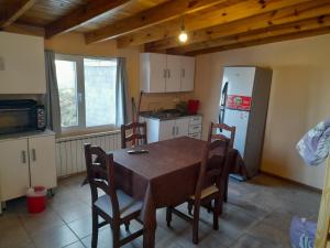 a kitchen with a table and chairs and a refrigerator at AzulTDF in Ushuaia