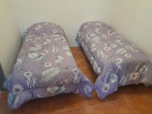 Una cama con una manta morada en la parte superior de un piso en AzulTDF, en Ushuaia 4 fotos más