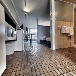 een kamer met een badkamer met een tv en een vloer bij Raceview Motor Inn in Toowoomba