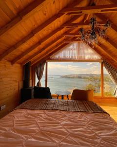 阿基塔尼亚Glamping Domos del Lago的一间带床和大窗户的卧室