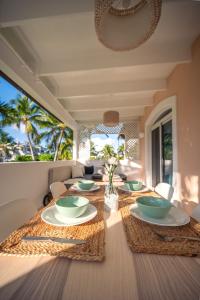 a dining room with a table with plates and bowls at Family Dominicus Apartment - Bayahibe in Bayahibe