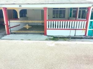 a house with a red and white fence at Yoni Homestay in Kampung Raja