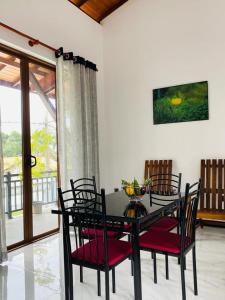 a dining room with a black table and chairs at Happy Homes in Kiribathgoda