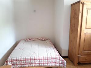 a small bedroom with a bed and a wooden cabinet at Appartement Albiez-Montrond, 2 pièces, 5 personnes - FR-1-618-7 in Albiez-Montrond
