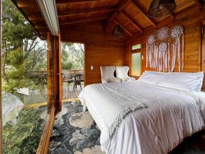 阿基塔尼亚Glamping Domos del Lago的木屋内的卧室配有一张大床 更多37张照片
