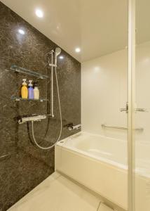 uma casa de banho com um chuveiro e uma banheira em ANA Crowne Plaza Sapporo, an IHG Hotel em Sapporo
