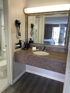 
a bathroom with a sink and a mirror at Wilkes-Barre Inn & Suites in Wilkes-Barre
