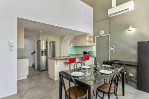 a dining room with a table and chairs in a kitchen at Tropical Nites Holiday Townhouses in Port Douglas