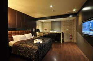 台中市にある采岩汽車旅館のベッド1台、薄型テレビが備わるホテルルームです。