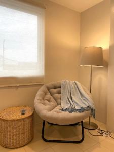Habitación con silla, lámpara y ventana en CRIB 227: Modern Fresh Vibe Condo en Olongapo