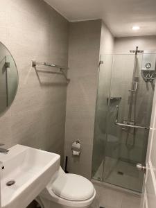 y baño con ducha, aseo y lavamanos. en CRIB 227: Modern Fresh Vibe Condo en Olongapo