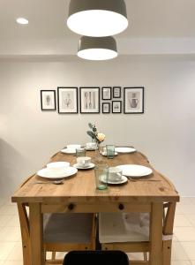 a wooden table with plates and dishes on it at CRIB 227: Modern Fresh Vibe Condo in Olongapo