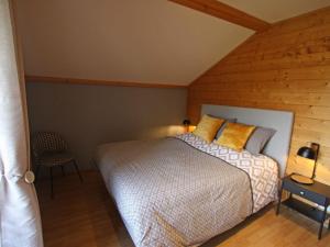 1 dormitorio con 1 cama y pared de madera en Gîte Rupt-sur-Moselle, 4 pièces, 6 personnes - FR-1-589-387, en Rupt-sur-Moselle