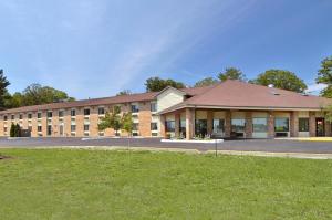 a large brick building with a grass field in front at Baymont by Wyndham Muskegon in Muskegon