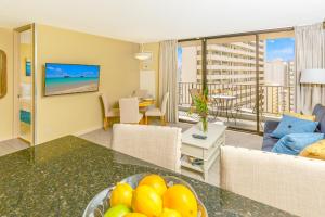 a living room with a table with a bowl of fruit at Waikiki Sunset Tropical Getaway with Free Parking! in Honolulu