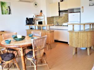 une cuisine avec une table et des chaises en bois dans l'établissement Appartement Climatisé 2P avec Parking, Proche Plage et Commerces à Cavalaire - FR-1-226B-99, à Cavalaire-sur-Mer 6 autres photos