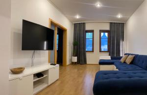 sala de estar con sofá azul y TV de pantalla plana en Apartmán Lara en Komárno