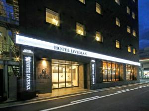 een 's nachts verlicht hotel naast een gebouw bij HOTEL LiVEMAX Chiba Chuo-Ekimae in Chiba