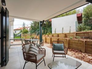 eine Terrasse mit Stühlen, einem Tisch und einem Zaun in der Unterkunft Appartement Saint-Jean-de-Luz, 2 pièces, 4 personnes - FR-1-4-617 in Saint-Jean-de-Luz