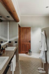 ein Badezimmer mit einem Waschbecken und einer Dusche mit einer Holztür in der Unterkunft Casa La Vina Villas Pokolbin in Pokolbin