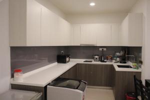 a kitchen with white cabinets and a washer at Suasana Suites D'Homestay2 JB Town in Johor Bahru +3 photos