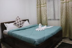 ein Schlafzimmer mit einem Bett mit einer blauen Decke in der Unterkunft RHODODENDRON stay in Darjeeling