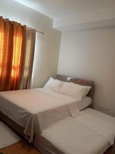 a small bedroom with two beds and a window at Mesaverte Residences Afs Suites - Studio in Cagayan de Oro +12 photos