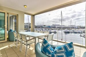 a balcony with a table and chairs and a marina at Superior Three Bedroom Apartment in Cape Town