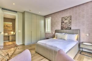 1 dormitorio con 1 cama grande y 2 sillas en Superior Three Bedroom Apartment en Ciudad del Cabo